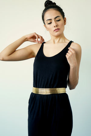 Image of woman posing with Gold Ndebele Belt wearing a black sleeveless top and black pants