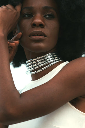 Close up of woman in a white dress posing with the Silver Ndebele Choker 